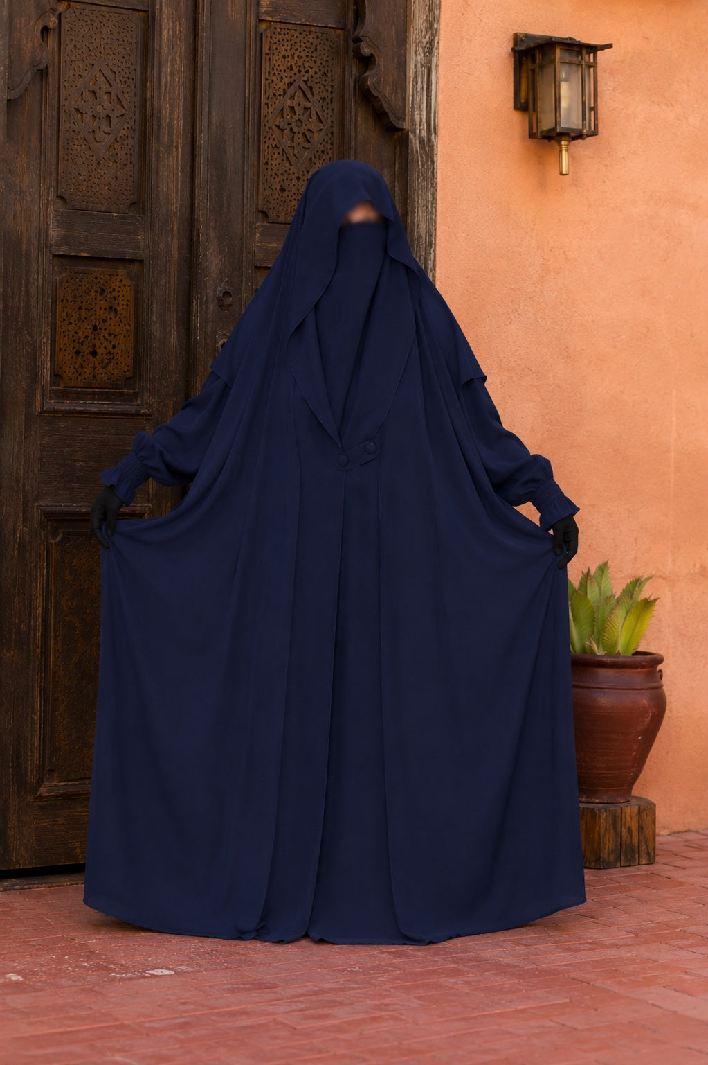 Jilbab Liyane bleu nuit à deux boutons en crêpe royale porté de face, montrant l'ampleur du tissu fluide et la coupe mastour.