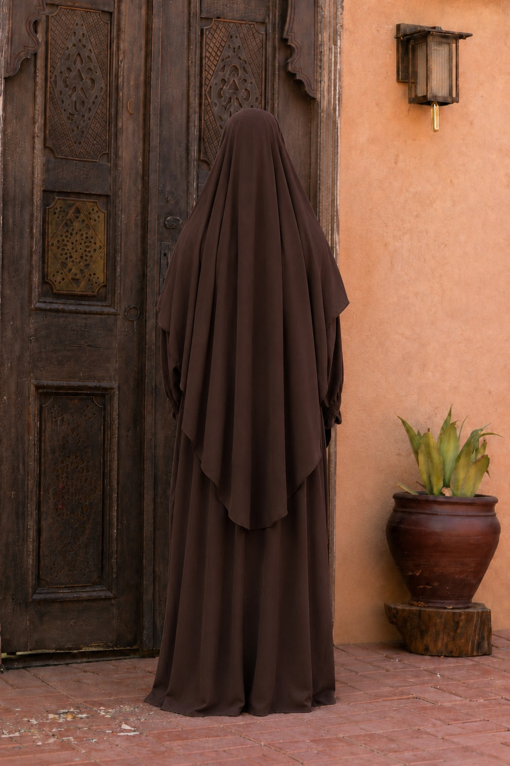 Vue arrière d'un jilbab 2 pièces marron chocolat en tissu crêpe royal avec khimar long couvrant et robe ample.