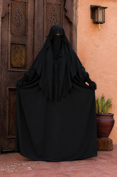 Jilbab 2 pièces noir en crêpe royal présenté de face, mettant en valeur l'ampleur de la jupe et le tombé fluide du tissu.