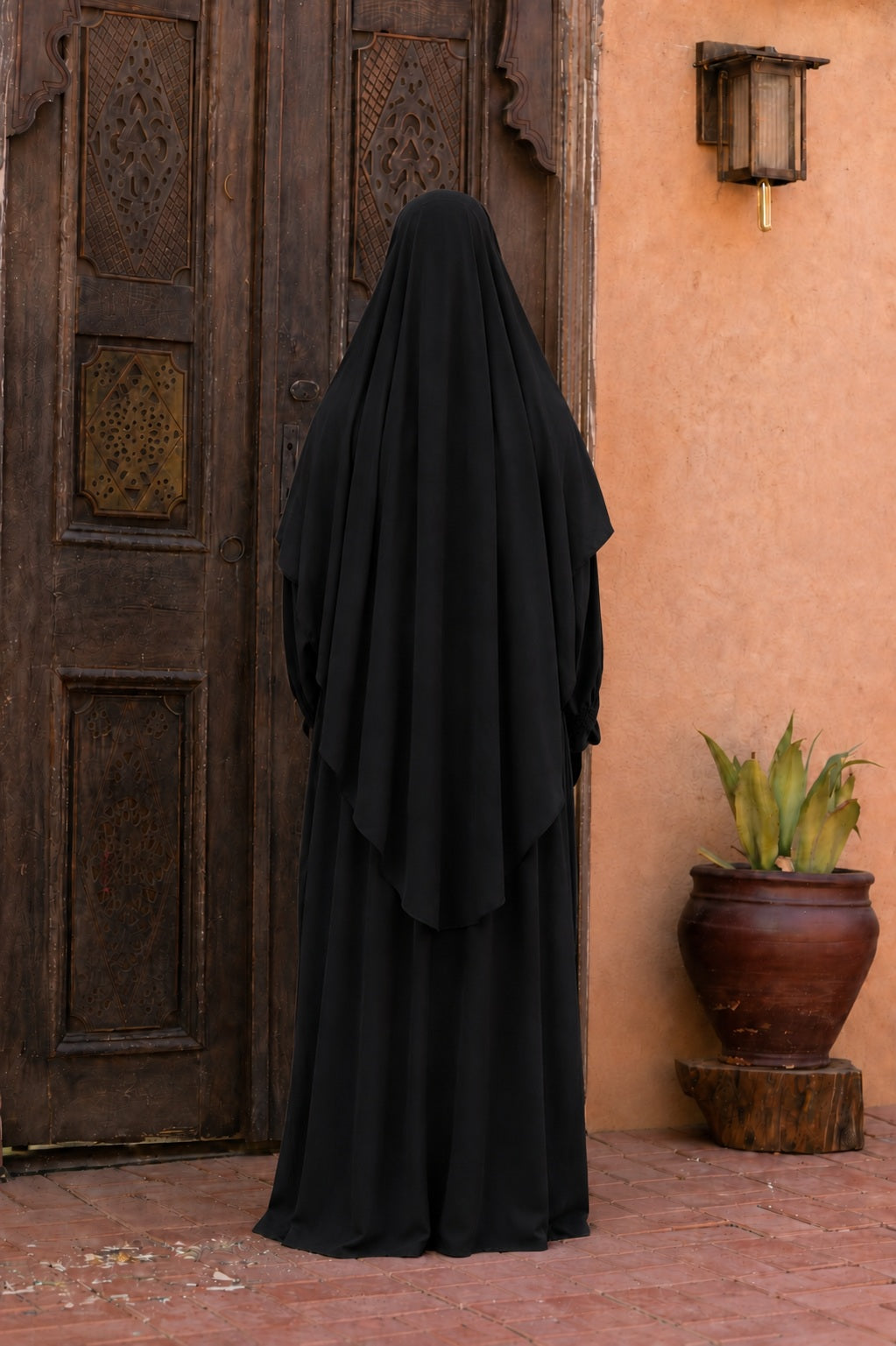 Vue arrière d'un jilbab 2 pièces noir en crêpe royal avec khimar long couvrant et coupe ample, offrant une silhouette élégante et mastour.