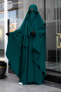 Jilbab 2 pièces vert canard avec manches larges et khimar long, présenté de face avec un bras ouvert, confection en crêpe premium.