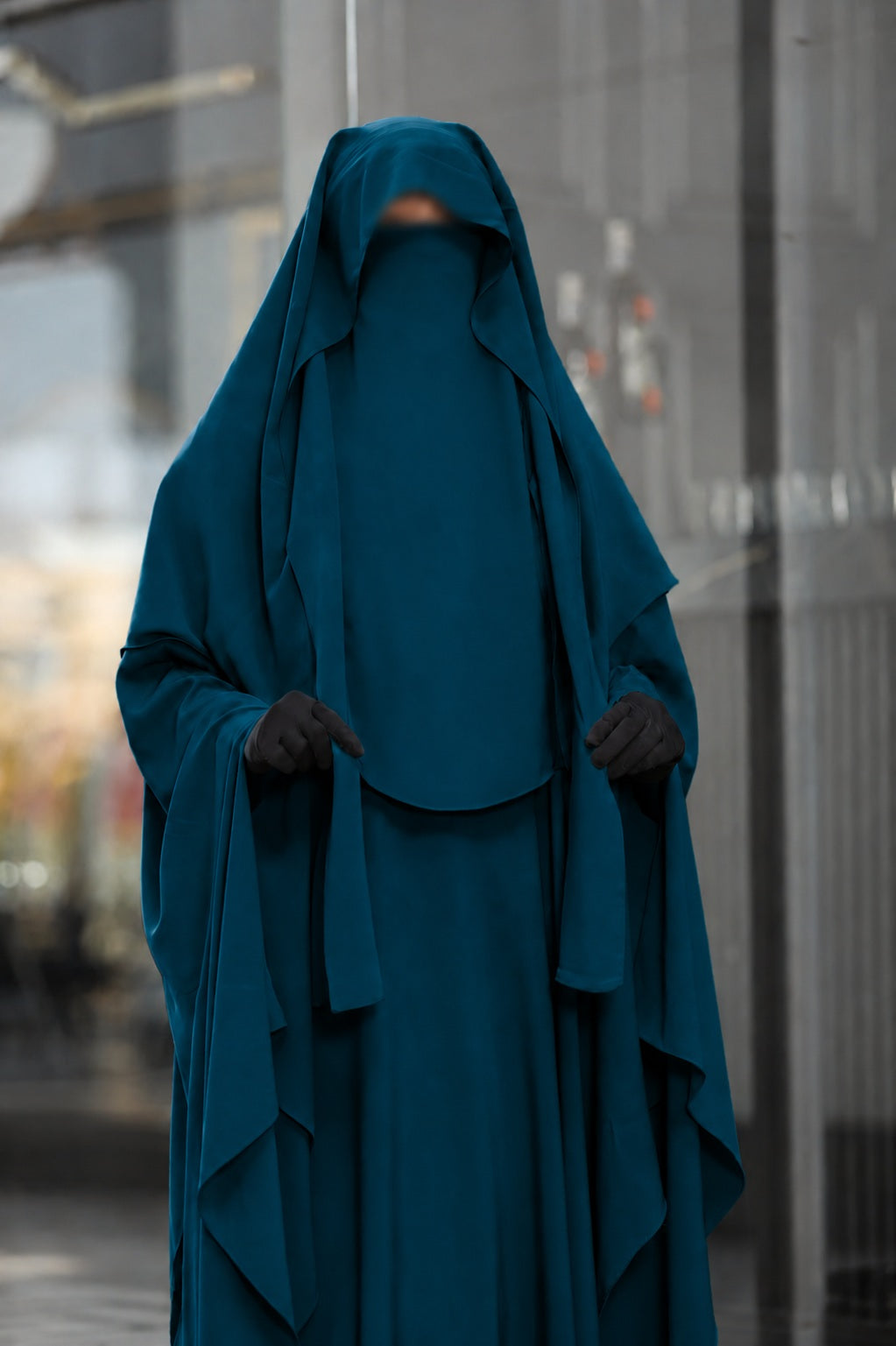 Vue de face du jilbab bleu canard mettant en valeur le khimar long, le voile fluide et la jupe ample en crêpe royale.