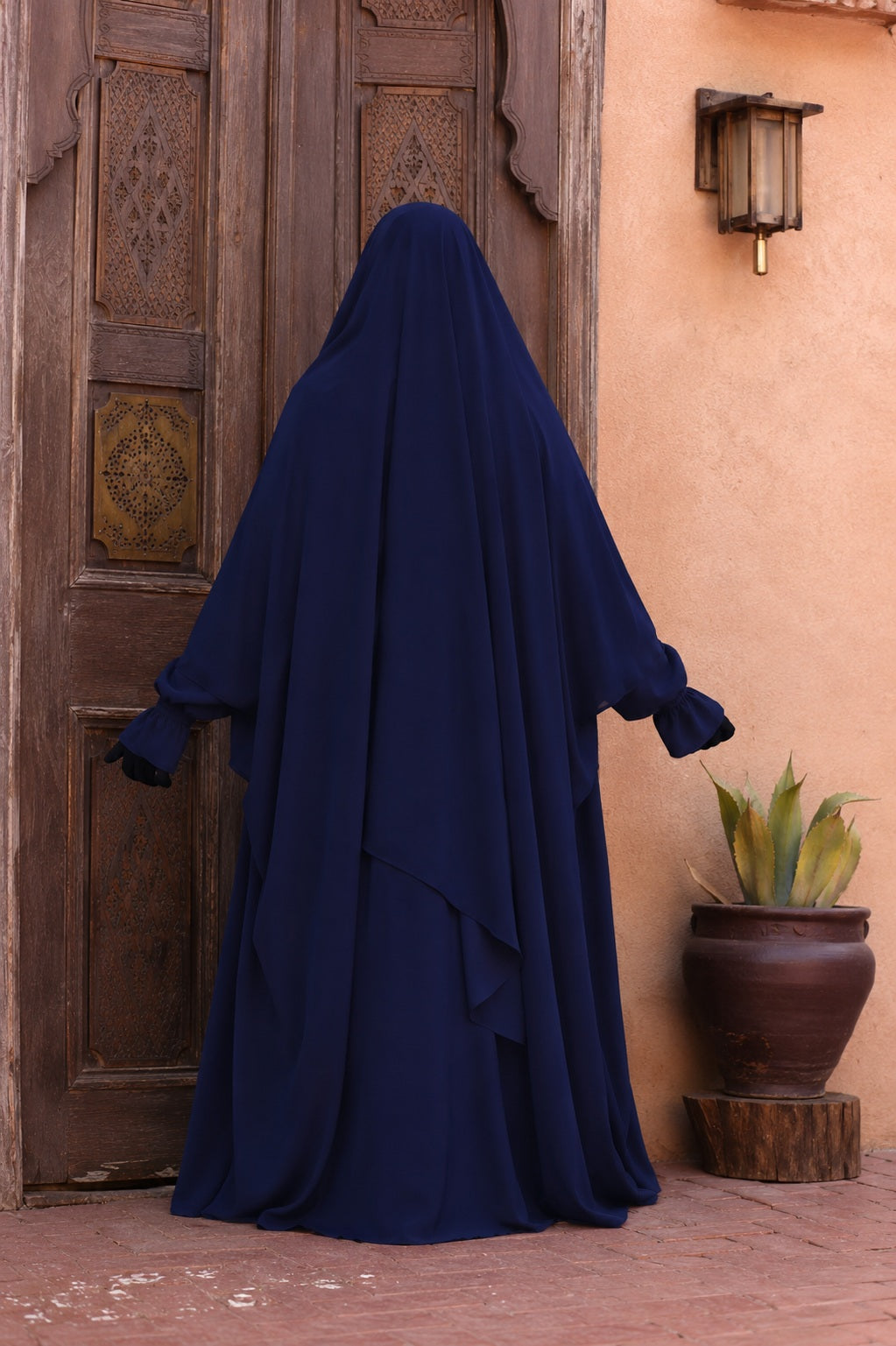 Vue de dos du jilbab Liyane bleu nuit à deux boutons en tissu crêpe royale, mettant en valeur la coupe ample, fluide et la couvrance complète du voile.