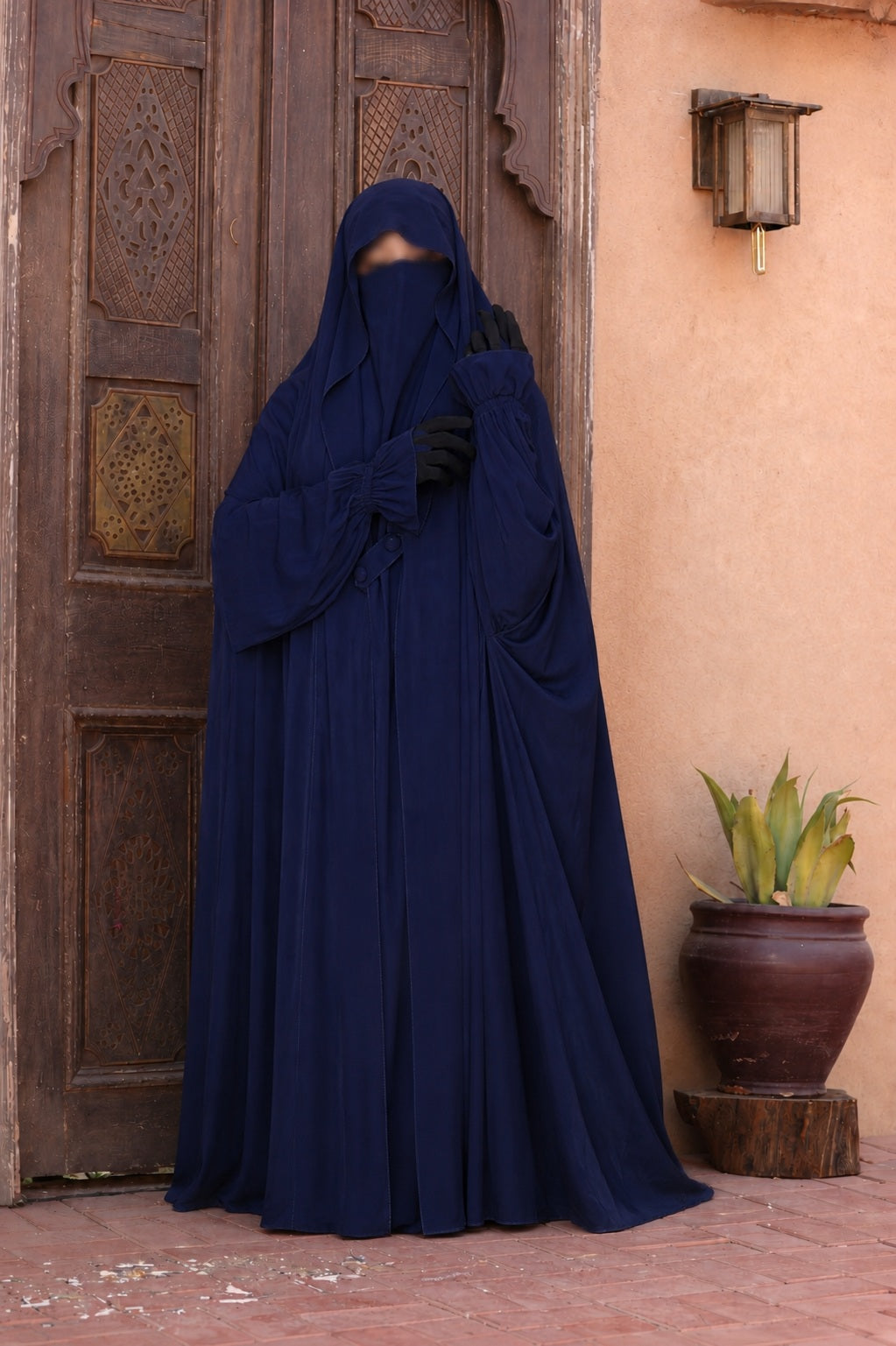 Jilbab Liyane bleu nuit à deux boutons en tissu crêpe royale, coupe longue, ample et fluide, porté avec élégance.