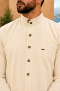 Détail du col officier d’un qamis homme vanille premium avec boutons carrés noirs et dorés au style saoudien élégant.