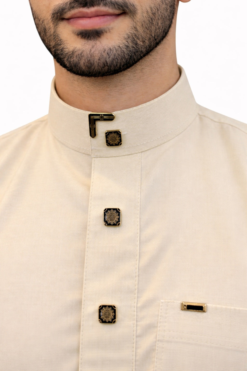 Détail du col officier d’un qamis homme vanille premium avec boutons carrés noirs et dorés au style saoudien élégant.